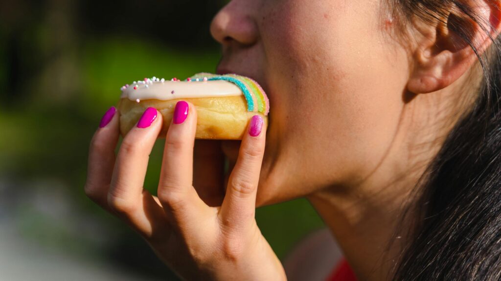 una chica mordiendo un donuts